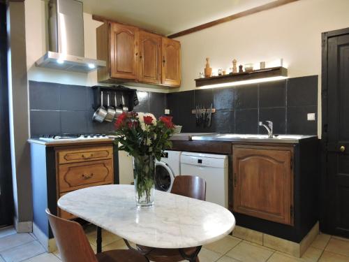 une cuisine avec une table avec un vase de fleurs dessus dans l'établissement Gîte Champagne LA PARCELLE, à Connigis