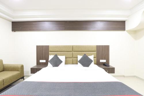 a bedroom with a large bed and a couch at Alba Premier, Ahmedabad in Ahmedabad