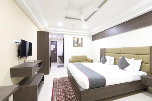a hotel room with a bed and a television at Alba Premier, Ahmedabad in Ahmedabad