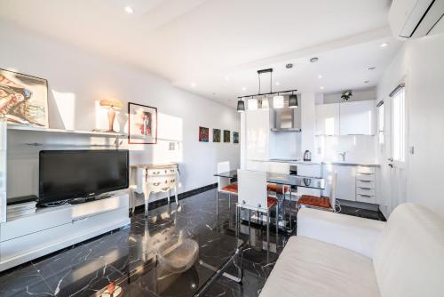 un salon avec des murs blancs et une grande télévision dans l'établissement Nice one bedroom heart of Cannes, à Cannes