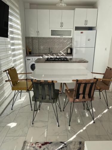 a kitchen with a table with chairs and a stove at BELKA GOLF RESİDENCE Poolside apt1 Belek in Belek
