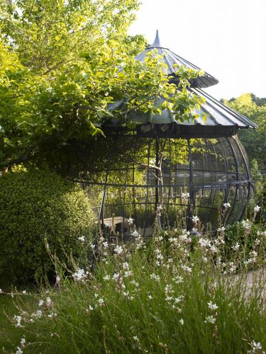 a bird cage in the middle of a garden at Baumanière - Les Baux de Provence in Les Baux-de-Provence