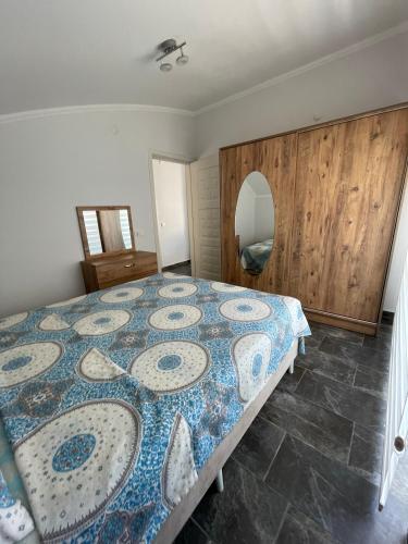 a bedroom with a bed with a blue and white quilt at BELKA GOLF RESİDENCE Poolside apt1 Belek in Belek