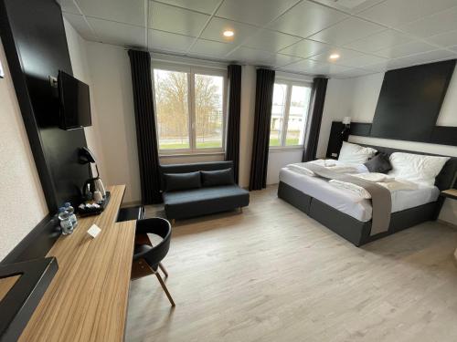 - une chambre avec un lit, un bureau et une chaise dans l'établissement Yebs Hotel, à Guntzbourg