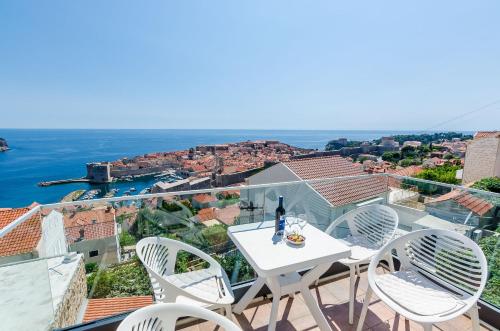 Una mesa y sillas en un balcón con vista al agua. en Apartments Isabora, en Dubrovnik