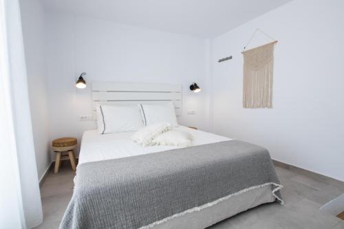 a white bedroom with a large bed with white sheets at Alkithea luxury suites in Karpathos Town