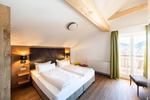 a bedroom with a large bed and a large window at Schnitzers Dahoam - Hundefreundlich in Bad Wiessee