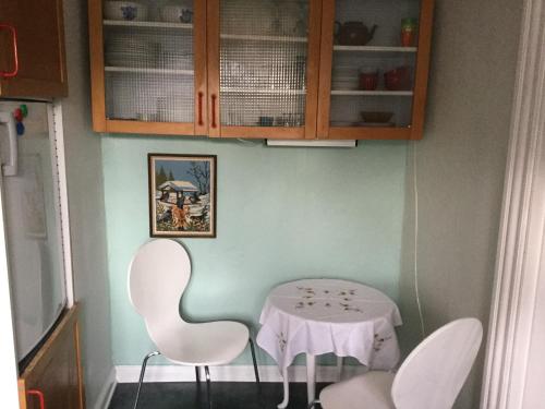 a table and chairs in a room with a white table and cabinets at Ribe centrum i fredet hus in Ribe