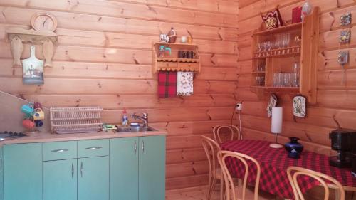 a kitchen with a table and a sink in a room at Vila Dovilas in Palanga