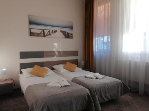 two beds in a hotel room with towels on them at Ośrodek Rehabilitacyjno-Wczasowy Magnolia in Kołobrzeg