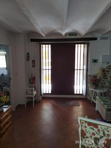 a living room with a large door and wooden floors at Rosita Casa Rural in Estivella