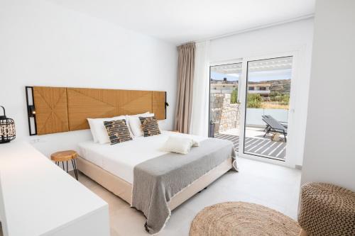a bedroom with a bed and a balcony at Alkithea luxury suites in Karpathos Town