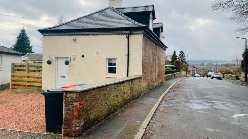 a house with a trash can next to a street at The Old Stables 17a in Dumfries