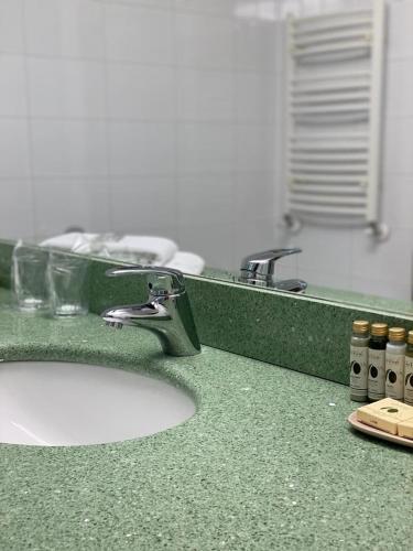 a bathroom counter with a sink and a mirror at The Gerald's Hotel in Rădăuţi