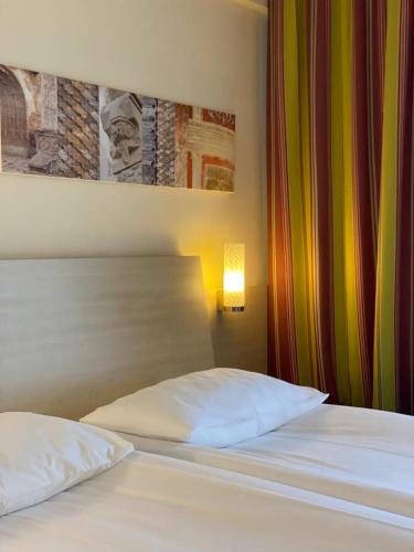 a bed with two white pillows in a bedroom at The Gerald's Hotel in Rădăuţi