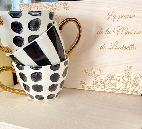 um par de canecas de café sentadas numa mesa em La Maison de Louisette em Le Faouët