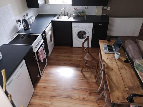 a kitchen with a sink and a washing machine at Pentwyn Barn in Brynamman