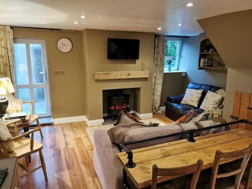 a living room with a couch and a fireplace at Pentwyn Barn in Brynamman