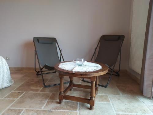 ein kleiner Tisch mit einer Schüssel neben zwei Stühlen in der Unterkunft Limone Vallée in Montrigaud