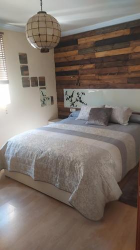 um quarto com uma cama grande e uma parede de madeira em Home St Nicolas Home VUT42/000161 em Soria