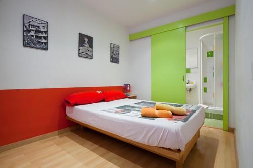 a bedroom with a bed with red and green walls at Nisia B&B in Barcelona