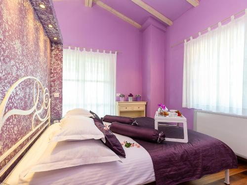 a bedroom with purple walls and a large bed at Villa Salvea with heated pool in Montižana
