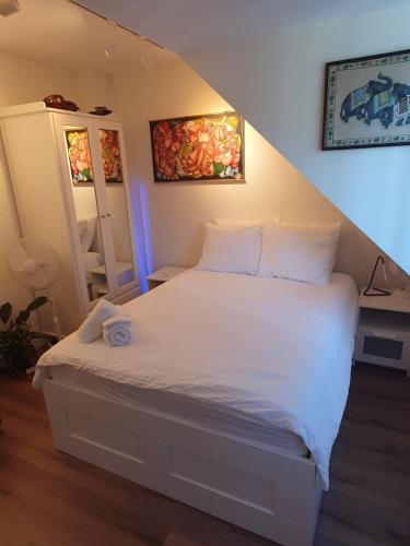 a bedroom with a bed with white sheets at Scheveningen Sea Side in The Hague
