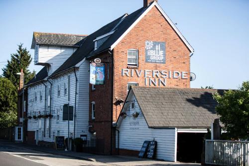 un edificio con un cartel en el costado en The Riverside Inn, en Chelmsford