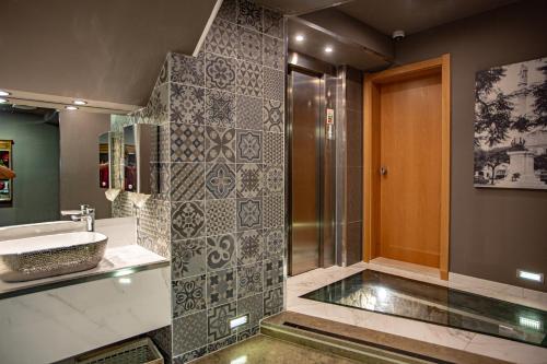 a bathroom with a sink and a shower at Hotel Bocage in Setúbal