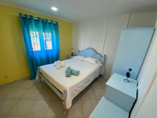 Un dormitorio con una cama y una cortina azul. en O Cantinho do Sol, en Lourinhã