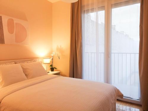 Un dormitorio con una cama y una ventana grande. en FilinHome Papa Suite 3, en Novi Sad