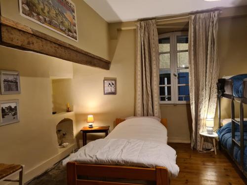 una piccola camera da letto con un letto e una finestra di Gîte d'étape Le Couvent d'Ossau a Louvie Juzon