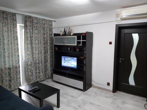 - un salon avec une télévision à écran plat dans un centre de divertissement dans l'établissement Apartment Ploiesti, à Ploieşti