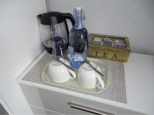 a shelf with a tea pot and a bottle on it at Vallum House in Carlisle