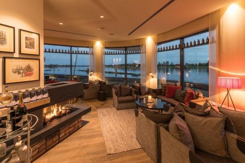 a living room with couches and a fireplace at Zollenspieker Fährhaus in Hamburg