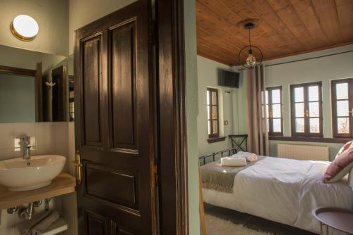 a bathroom with a bed and a sink in a room at Charis Guesthouse in Makrinítsa