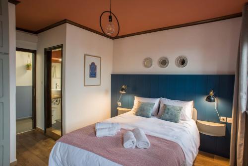 a bedroom with a large bed with towels on it at Charis Guesthouse in Makrinítsa