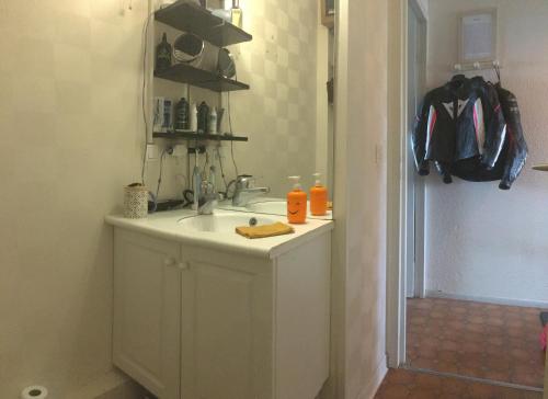 une salle de bain avec un lavabo et un comptoir avec des bouteilles d'orange dans l'établissement Chambre Chez l'Habitant BIDART à 300 M de la Mairie et Plage, à Bidart