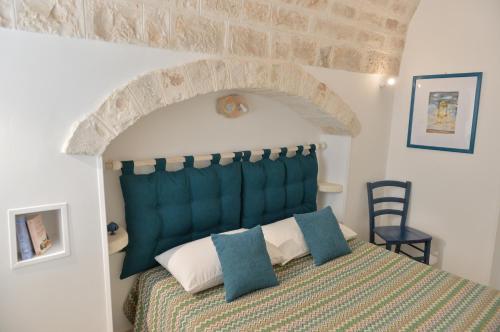 een slaapkamer met een bed met een groen hoofdeinde bij I Trulli del Tempo in Martina Franca