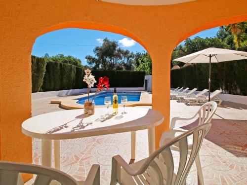una mesa y sillas en un patio con una pared de color naranja en Villa Villa Maria by Interhome, en La Canuta