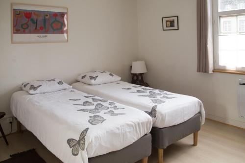 twee bedden naast elkaar in een slaapkamer bij Appartement Le bain aux plantes in Straatsburg