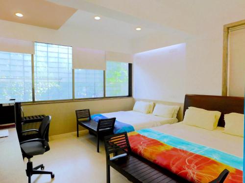 a bedroom with a bed and a desk and chairs at Apartment In Mumbai City Centre in Mumbai