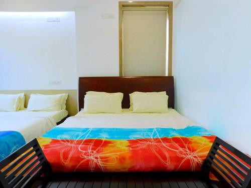 a bedroom with two beds with a colorful blanket at Apartment In Mumbai City Centre in Mumbai