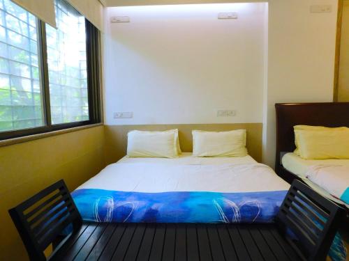 1 Schlafzimmer mit 2 Betten und 2 Fenstern in der Unterkunft Apartment In Mumbai City Centre in Mumbai