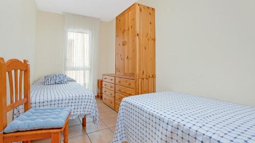 a bedroom with two beds and a wooden dresser at 1 Monts - Llafranc in Llafranc