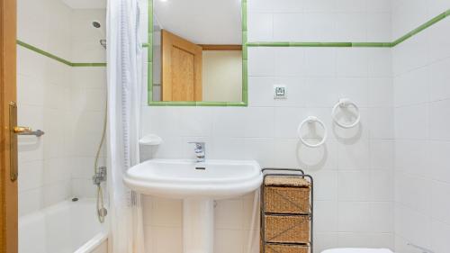 a white bathroom with a sink and a mirror at 1 Monts - Llafranc in Llafranc