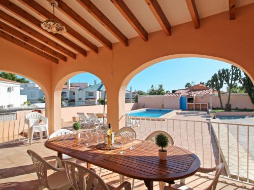 un patio con mesa, sillas y piscina en Villa Enrique by Interhome, en Calpe