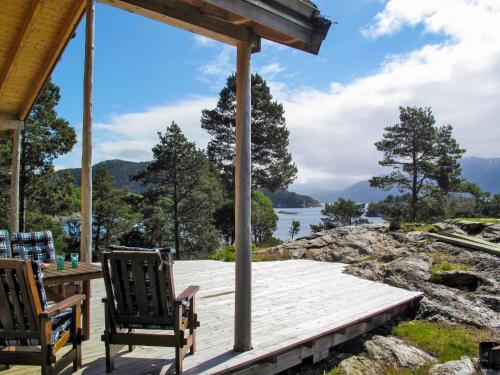 a porch with chairs and a table and a view of a lake at Chalet Svanöy by Interhome 