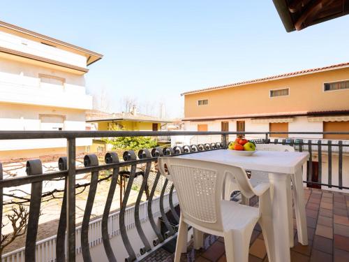 a white table and chairs on a balcony at Apartment Guglielmo e Anna by Interhome in Lignano Sabbiadoro