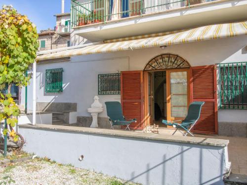 ein Haus mit zwei Stühlen und einem Tisch auf einer Veranda in der Unterkunft Apartment Kiwi e L'uva by Interhome in Fabrica di Roma